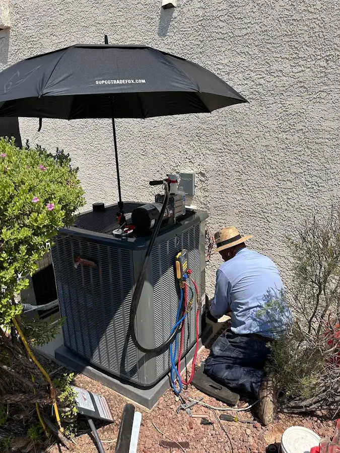 HVAC technician performing outdoor AC maintenance in Derby