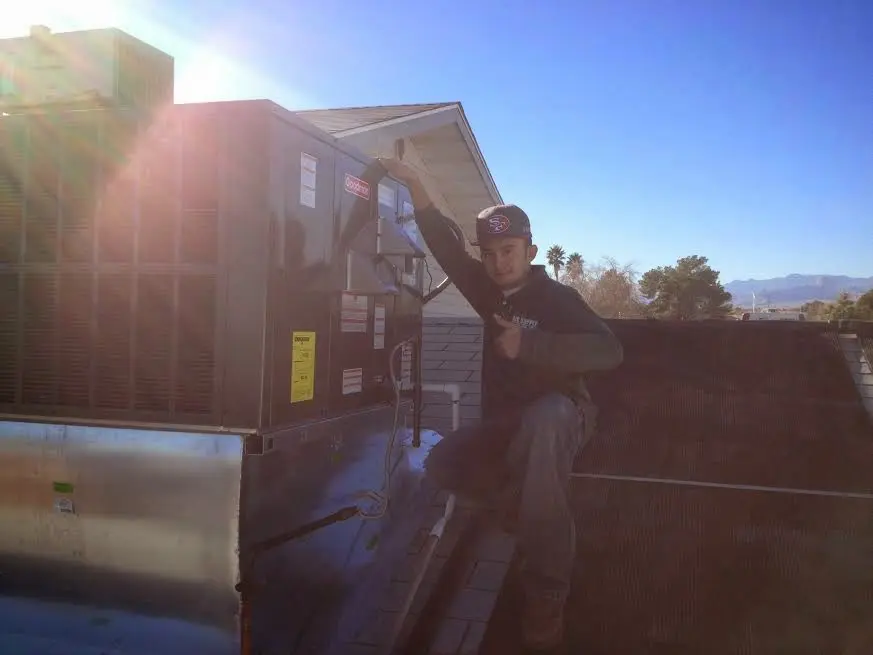 HVAC technician performing Air Duct Repair on a rooftop unit in Derby